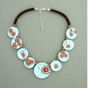 collier perles plates  fond turquoise clair fleur marron